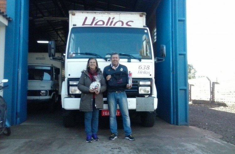 Um homem e uma mulher em frente a uma garagem segurando um premio.